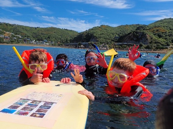 Children in the water wearing snorkelling gear and life jackets