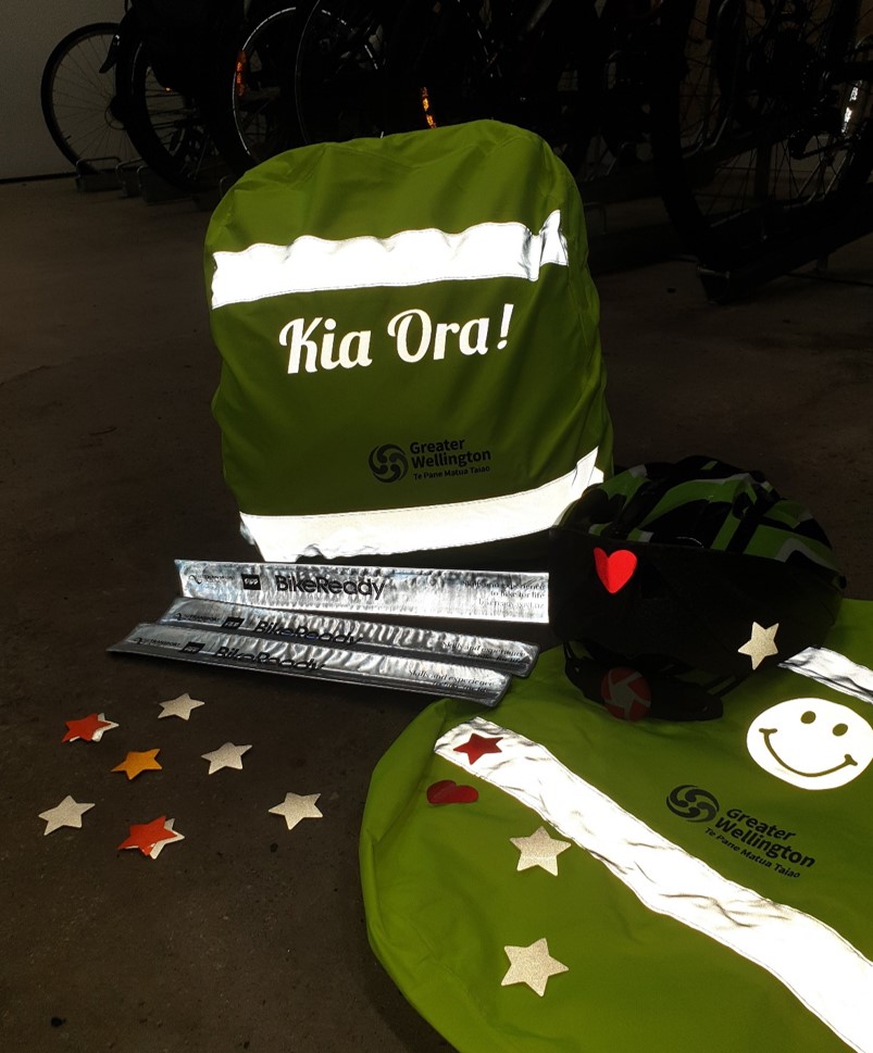 Reflective items with a light shone on them in the dark - a backpack cover, snap bracelets/anklets, and star stickers